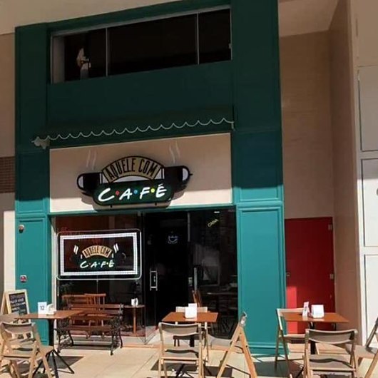 Fachada do Aquele com Café em Águas Claras, com o letreiro da casa e as mesas na calçada